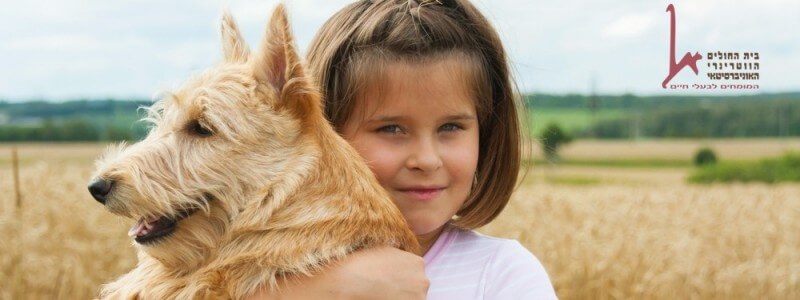 ילדה מחבקת כלב טיפולי